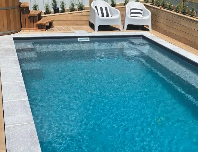 Element fibreglass pool with a wraparound bench on a timber deck